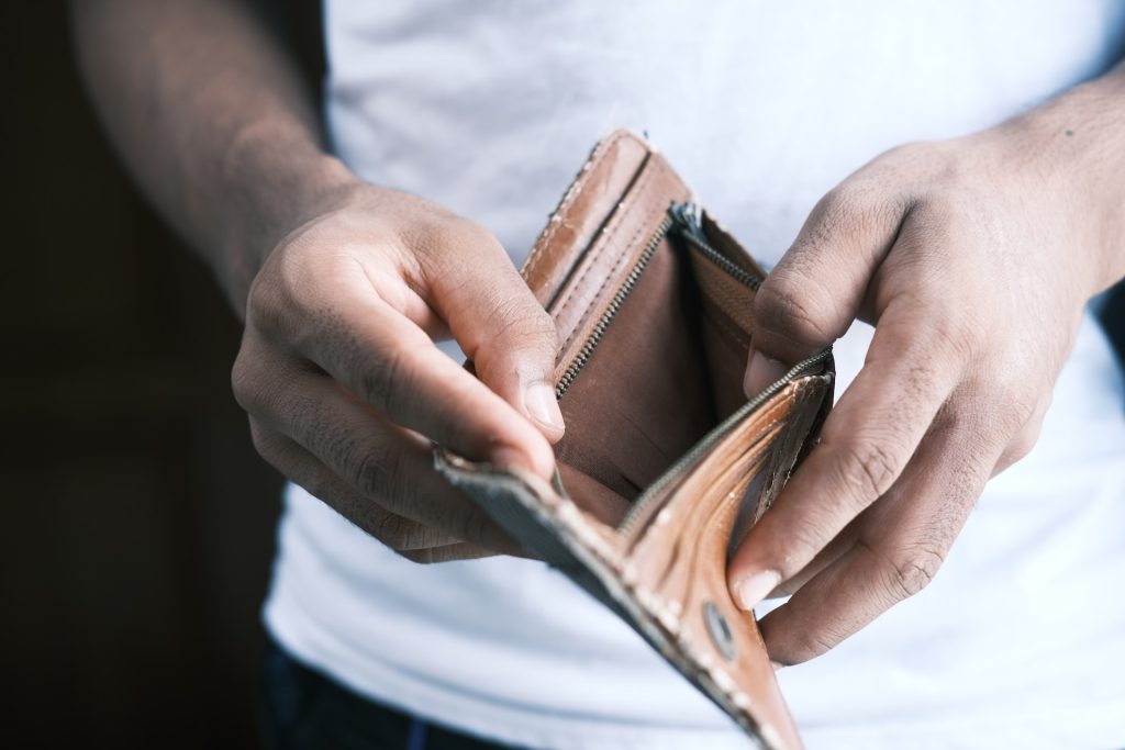 hombre con billetera vacía solicita un préstamo para liquidar deudas